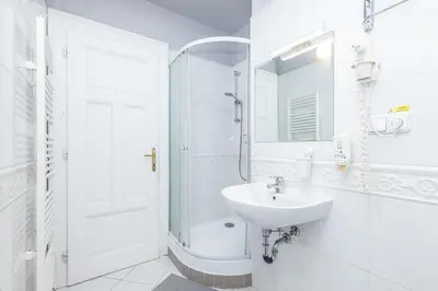 a white bathroom with a sink and a shower at Antiveli Residence in Prague