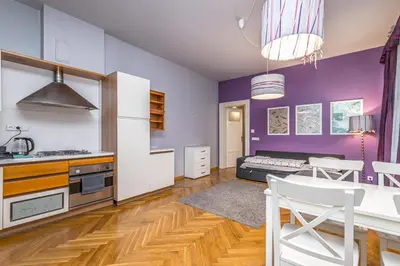 a kitchen with purple walls and a table and chairs at Antiveli Residence in Prague