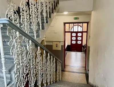 a stairway with a wrought iron railing and a red door at La casa Prokop in Prague