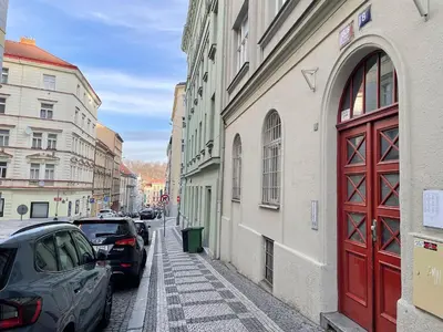 a red door on the side of a building with parked cars at La casa Prokop in Prague