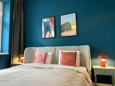a blue bedroom with a bed with three pictures on the wall at La casa Prokop in Prague