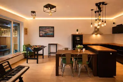 a kitchen and living room with a table and a piano at Sauna Apartement, 3 bedrooms, Praha 8 in Prague