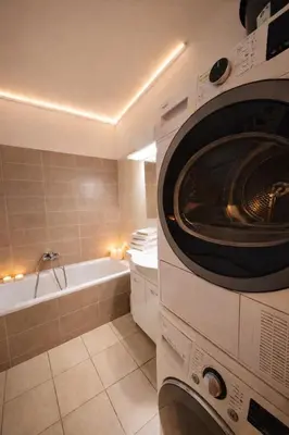 a bathroom with a washer and a bath tub at Sauna Apartement, 3 bedrooms, Praha 8 in Prague