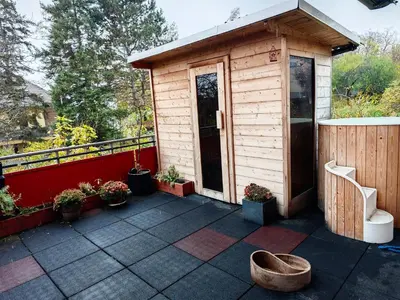 a small wooden shed with a bench on a patio at Sauna Apartement, 3 bedrooms, Praha 8 in Prague