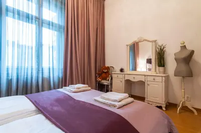 a bedroom with a bed with a mirror and a dresser at Staropramenna Garden Residence in Prague