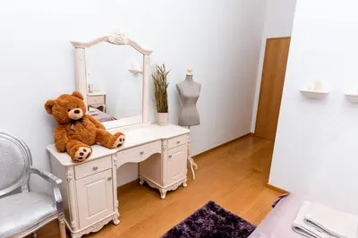 a teddy bear sitting on a dresser in front of a mirror at Staropramenna Garden Residence in Prague