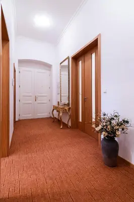 a hallway with a table and a vase of flowers at Staropramenna Garden Residence in Prague