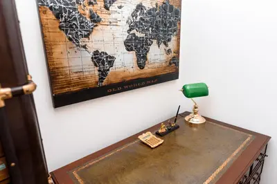 a desk with a lamp and a map on the wall at Staropramenna Garden Residence in Prague