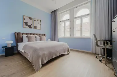 a bedroom with a bed with blue walls and a window at Blueground Prague 2 renovated Riegrovy sady PRG-30 in Prague