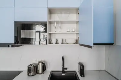 a kitchen with white cabinets and a sink at Blueground Prague 2 renovated Riegrovy sady PRG-30 in Prague