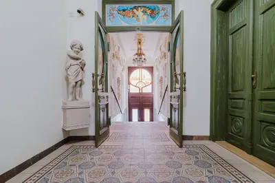a hallway with green doors and a statue on the wall at Blueground Prague 2 renovated Riegrovy sady PRG-30 in Prague