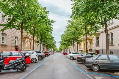 a row of cars parked on a street with trees at Blueground Prague 2 renovated Riegrovy sady PRG-30 in Prague