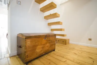a room with a wooden chest next to a staircase at The Spot Apartment in Prague