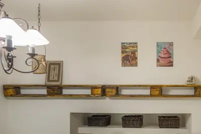 a wooden shelf on a wall with pictures and a lamp at The Spot Apartment in Prague