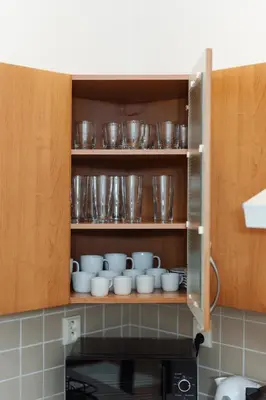 a cupboard filled with bowls and plates in a kitchen at Louvre - Cozy City Center Apartment with Balcony in Prague