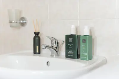 a bathroom sink with two bottles of soap and toothbrushes at Louvre - Cozy City Center Apartment with Balcony in Prague