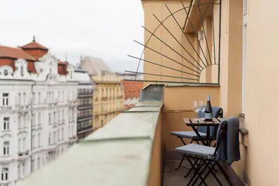 a balcony with a table and chairs on a building at Louvre - Cozy City Center Apartment with Balcony in Prague