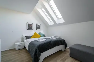 a white bedroom with a bed and a skylight at Florenc Charming Studio in Prague