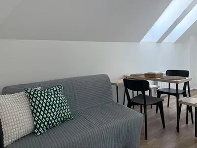 a living room with a couch and a table with chairs at Florenc Charming Studio in Prague