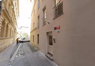 a person walking down a alley between two buildings at Florenc Charming Studio in Prague