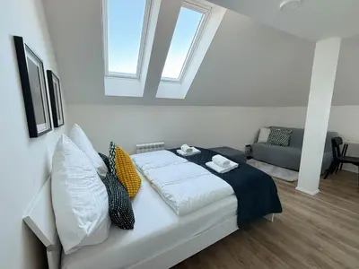 a room with a bed with pillows and a window at Florenc Charming Studio in Prague