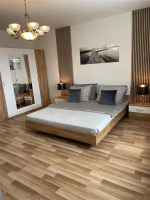 a bedroom with a large bed and wooden floors at Aparthotel Praha in Prague