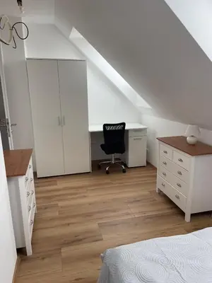 an attic bedroom with a desk and a chair at Aparthotel Praha in Prague