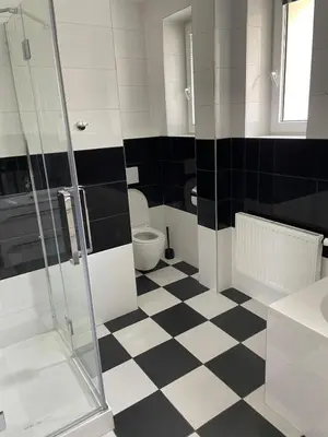 a bathroom with a black and white checkered floor at Aparthotel Praha in Prague