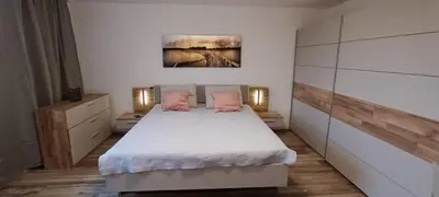 a bedroom with a bed with white sheets and pink pillows at Aparthotel Praha in Prague