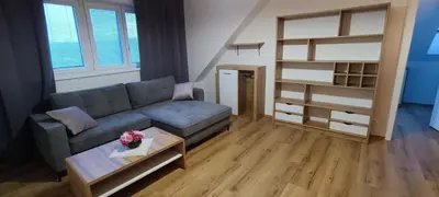 a living room with a couch and a book shelf at Aparthotel Praha in Prague