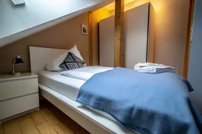 a bedroom with a bed with a blue blanket on it at Olives Ruterra Loft with Sauna in Prague