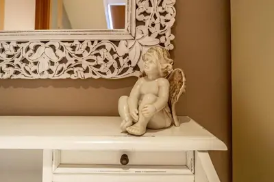 a cherub statue sitting on a table in front of a mirror at Olives Ruterra Loft with Sauna in Prague