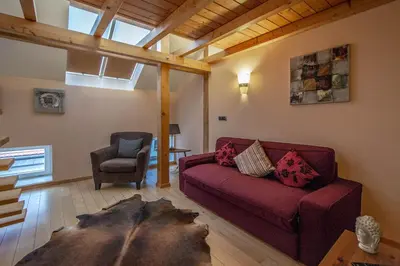 a living room with a red couch and a chair at Olives Ruterra Loft with Sauna in Prague