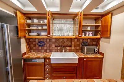 a kitchen with wooden cabinets and a sink at Olives Ruterra Loft with Sauna in Prague