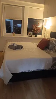 a bedroom with a large white bed with a window at Apartmán Pohoda in Prague
