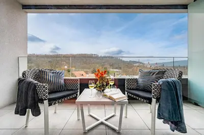 a balcony with two chairs and a table and a window at Prague Days - Studio with Terrace and Garage in Modern Building in Prague