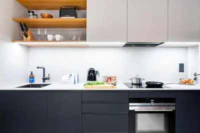 a kitchen with a black and white counter top at Prague Days - Studio with Terrace and Garage in Modern Building in Prague