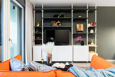 a living room with a couch and a tv at Prague Days - Studio with Terrace and Garage in Modern Building in Prague