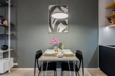 a dining room with a white table and chairs at Prague Days - Studio with Terrace and Garage in Modern Building in Prague