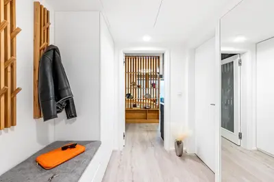 a hallway with white walls and an orange object on a bench at Prague Days - Studio with Terrace and Garage in Modern Building in Prague