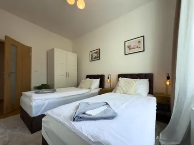 a bedroom with two beds with white sheets at 100m2 Wenceslas Comfort, 3BDR with Netflix in Prague
