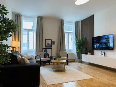 a living room with a couch and a tv at 100m2 Wenceslas Comfort, 3BDR with Netflix in Prague