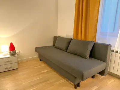 a couch sitting in a living room next to a window at Cozy Apartment by Wenceslas Square and Main Train Station in Prague