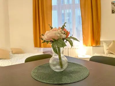 a glass vase with flowers in it on a table at Cozy Apartment by Wenceslas Square and Main Train Station in Prague