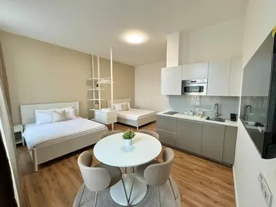 a small room with a bed and a table and chairs at Modern 2BED with st Ludmila view and entire square in Prague