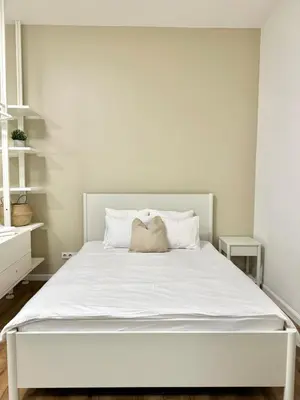 a white bedroom with a large bed with white sheets at Modern 2BED with st Ludmila view and entire square in Prague