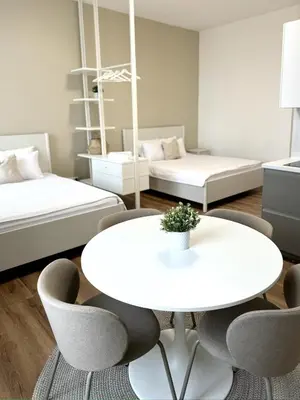 a room with a table and chairs and two beds at Modern 2BED with st Ludmila view and entire square in Prague