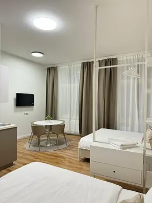a bedroom with two beds and a table with chairs at Modern 2BED with st Ludmila view and entire square in Prague