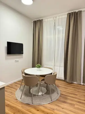 a dining room with a white table and chairs at Modern 2BED with st Ludmila view and entire square in Prague