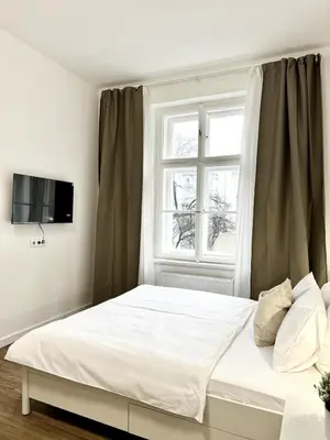 a bedroom with a white bed with a window at Cozy One-Room Apartment in heart of Prague in Prague